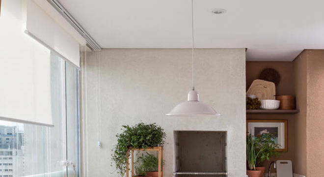 Varanda com churrasqueira e mesa de madeira