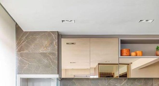 Varanda com churrasqueira e mesa de madeira