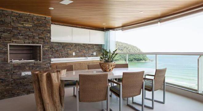 Varanda com churrasqueira e revestimento de pedra