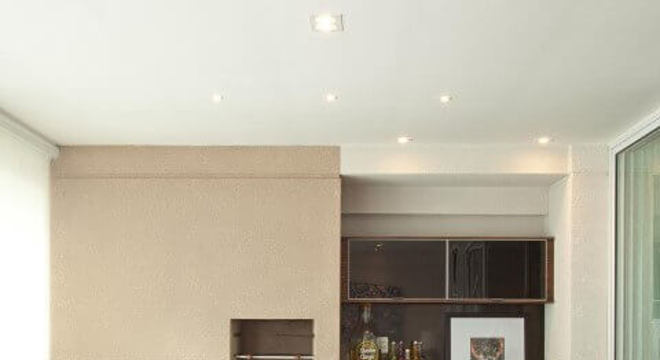 Varanda com churrasqueira pequena e balcão de madeira