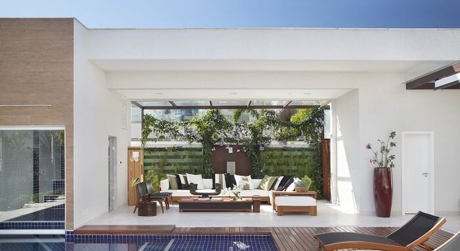 Varanda com jardim vertical integrada a piscina