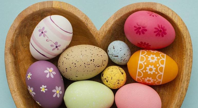 Vários ovos com a casca pintada, colocados dentro de uma cesta em formato de coração. Freepik