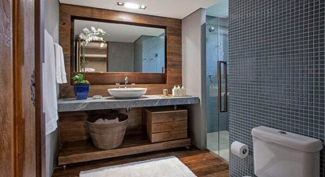 Vaso de flor e bandeja usados como enfeites para bancada de banheiro