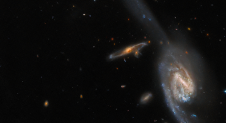 A imagem acima mostra duas das galáxias do trio galáctico Arp 248, também conhecido como Wild's Triplet (
