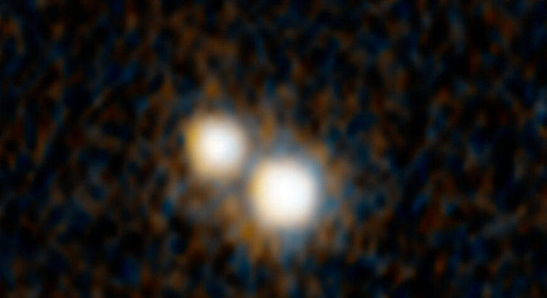 O par de quasares na imagem do telescópio espacial Hubble existe desde que o Universo tinha apenas 3 bilhões de anos — se estima que hoje, esteja por volta de 13,8 bilhões. Os quasares, que são um núcleo galáctico ativo, estão embutidos dentro de um par de galáxias em colisão. Com a imagem do Hubble, se comprova que se tratam de uma dupla quasar, ou seja, buracos negros supermassivos
