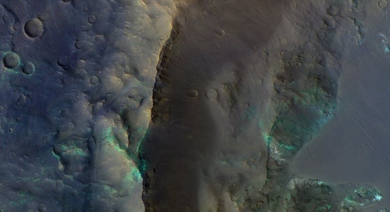 A borda da cratera Alga, localizada nas terras altas do sul de Marte, foi registrada pelo dispositivo Color and Stereo Surface Imaging System (CaSSIS), a bordo do ExoMars Trace Gas Orbiter. A cratera se destaca pelas cores esverdeadas, por causa de minerais máficos, e os tons mais azuis são mais cobertos de poeiraVEJA TAMBÉM: Telescópios e cientistas registraram imagens únicas do espaço em 2022; confira as melhores