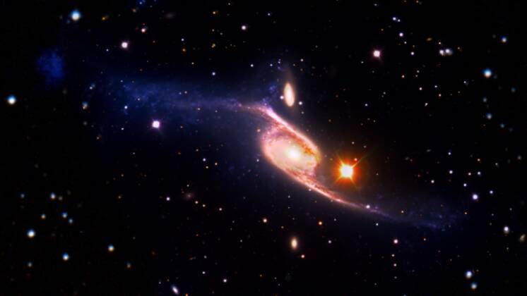Essa imagem da galáxia espiral gigante NGC 6872, de 10 de janeiro de 2013, combina imagens de luz visível do Very Large Telescope, do European Southern Observatory, junto com dados de ultravioleta distante do Galaxy Evolution Explorer (GALEX) da Nasa e dados infravermelhos adquiridos pelo Spitzer Space, da Nasa Telescópio. A NGC 6872 é a maior galáxia espiral conhecida