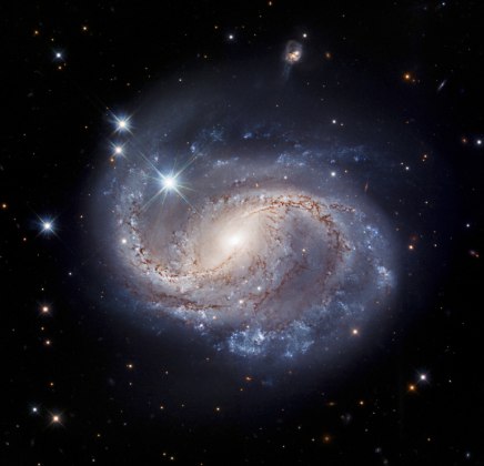 A galáxia NGC 6956 está localizada a 214 milhões de anos-luz da Terra, na constelação Delphinus. Essa é uma galáxia em espiral barrada, isso significa que existe uma banda central de estrelas brilhantes que se estendem pelos lados dela