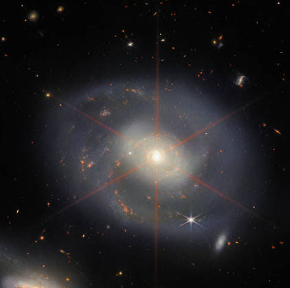 A galáxia espiral NGC 7469 foi registrada pelo Telescópio Espacial James Web. A imagem, divulgada em 21 de dezembro de 2022, permite que a galáxia bastante empoeirada possa ser vista com mais definição, graças a visão infravermelha do telescópio