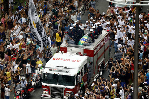 O carro dos bombeiros se aproxima do Memorial onde Pelé será sepultado, porém multidão nas ruas dificulta trajeto do cortejo