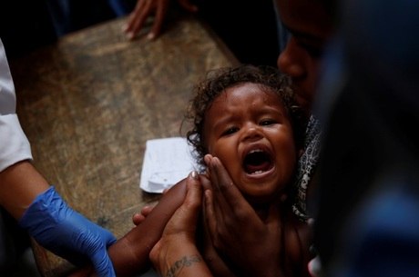 Menina chora após ser vacinada por voluntário