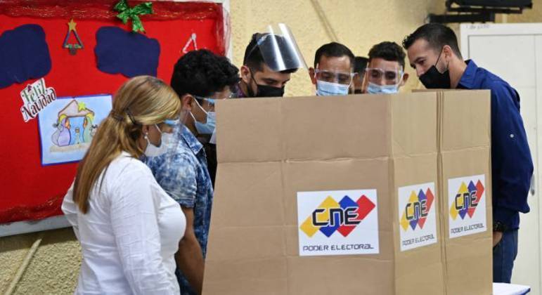 Autoridades e técnicos verificam uma máquina de votação em Caracas