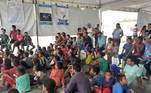 Venezuelanos reunidos para assistir televisão em abrigo de Boa Vista