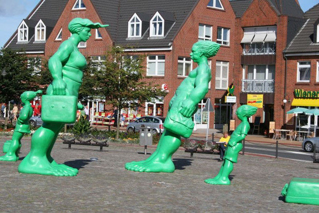 Viajantes no Vento (Reisende im Wind) - Alemanha -  Os personagens gigantes verdes, criados por Martin Wolke, caminham em meio a uma tempestade que só eles sentem. A obra fica em Westerland.  