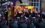 Soldados vestidos com o tradicional kilt escocês carregam o caixão que transporta o corpo da monarca