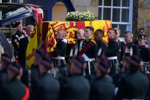 Soldados vestidos com o tradicional kilt escocês carregam o caixão que transporta o corpo da monarca