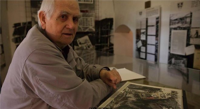 Vintrova Mandrholec posa com fotos de satélite do campo de trabalhos forçados onde ficou preso