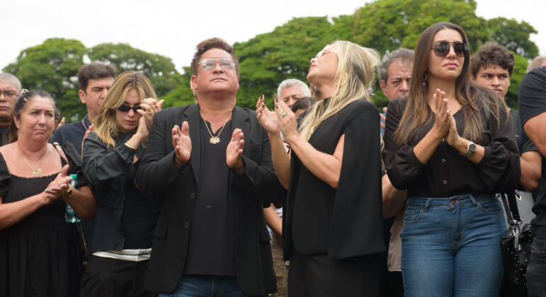 Leonardo, Virginia Fonseca, Poliana Rocha, amigos e familiares fazem uma oração no enterro de Carmem Costa