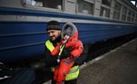 Voluntário carrega bebê em estação de trem na Ucrânia. Mais de um milhão de pessoas deixou o país após o início da invasão russa