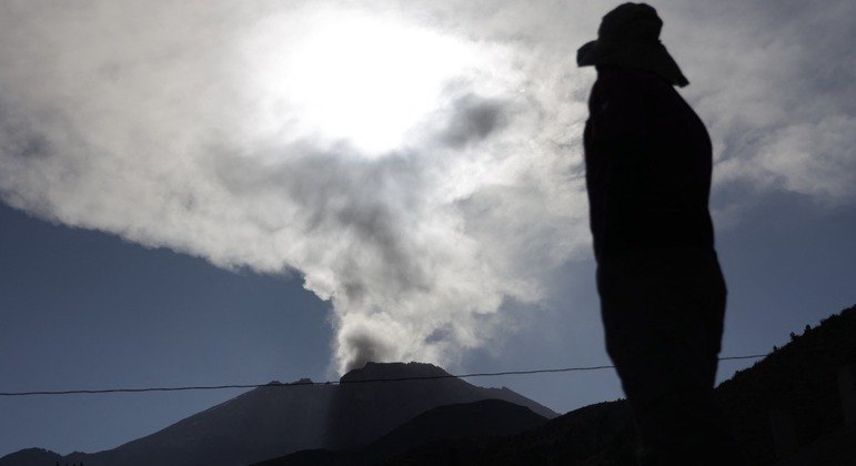 Um fazendeiro observa a nuvem de fumaça e cinzas subir do vulcão Ubinas, no Peru