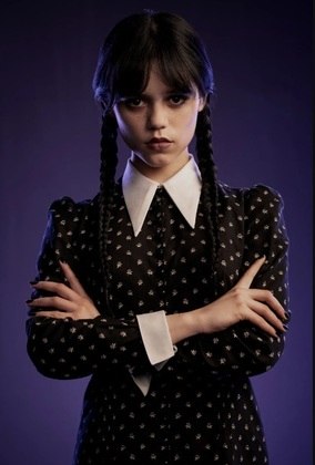 As trancinhas e a franja do cabelo são marcas registradas da personagem. A gola da camisa branca para fora do vestido também não pode faltar no look