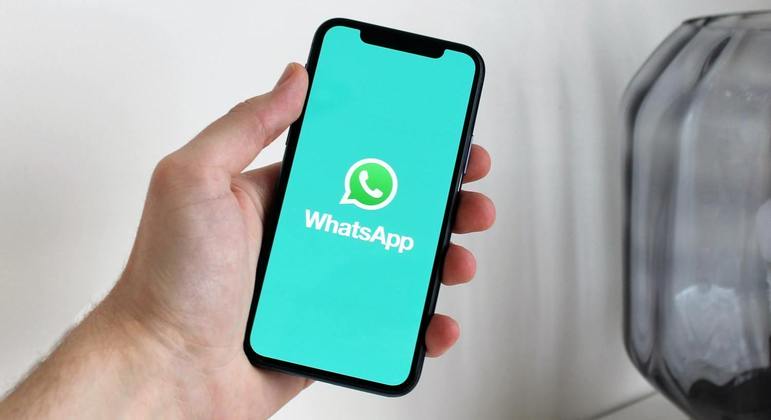 Celular na mão de usuário com o aplicativo WhatsApp
