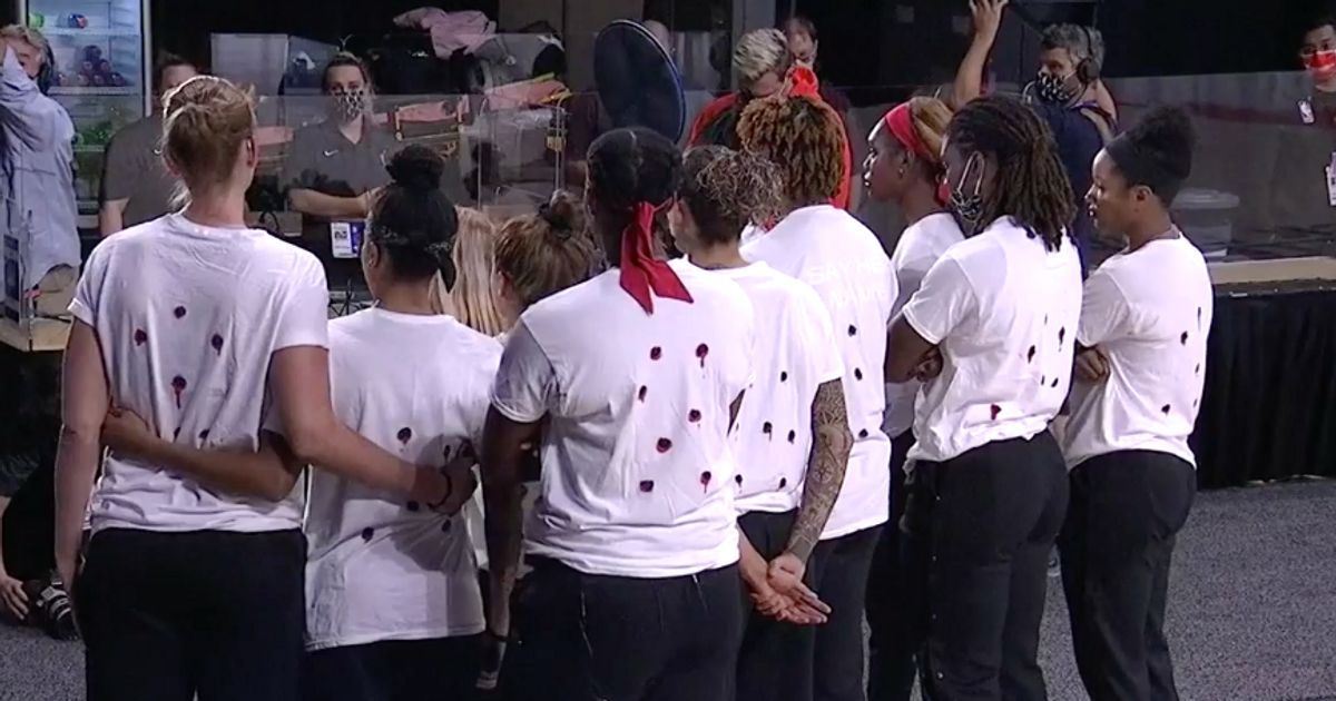 As jogadoras de basquete com camisetas representando sete buracos de bala