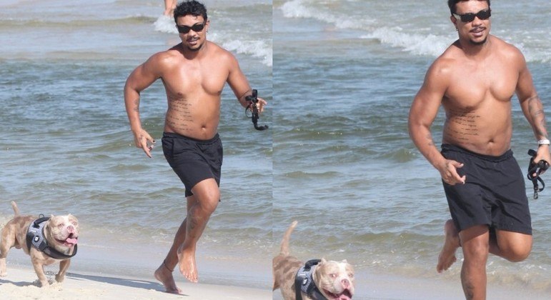 Xamã correndo com o cachorrinho dele em praia do Rio