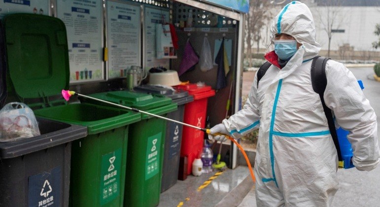 Um funcionário pulveriza desinfetante em uma área residencial de Xian no domingo (23)