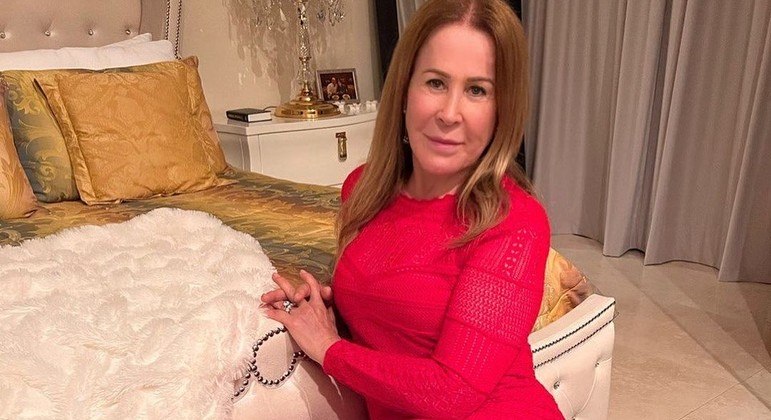 Zilu Godoi posou no quarto dela, de vestido vermelho e descalça 