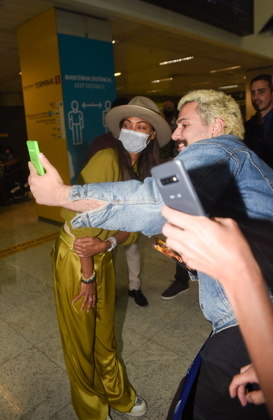 Simpática, Zoë atendeu alguns de seus fãs no aeroporto, posando para fotos e dando autógrafos